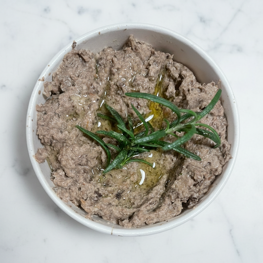 Mushroom pate with rosemary in a white bowl on a white background